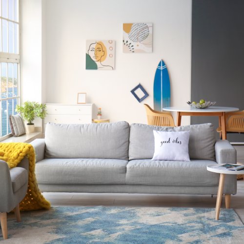 A modern living room featuring a surfboard against the wall, adding a relaxed, coastal vibe to the stylish space.