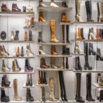 A display of women's autumn and winter boots in various styles and colors on the shelves in the store.