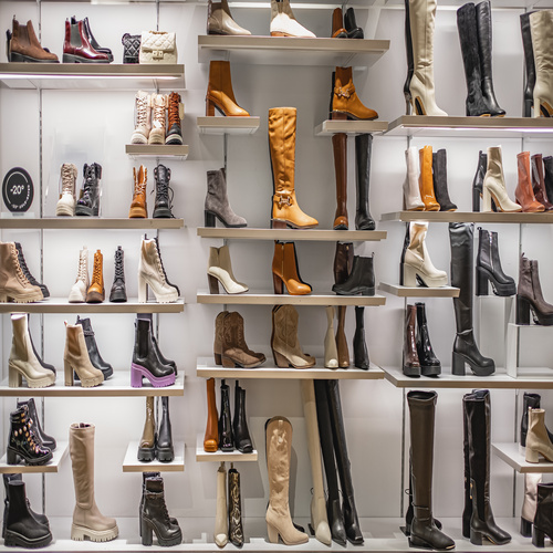 A display of women's autumn and winter boots in various styles and colors on the shelves in the store.